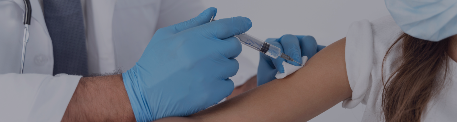 Doctor giving vaccinations to a patient ina workplace